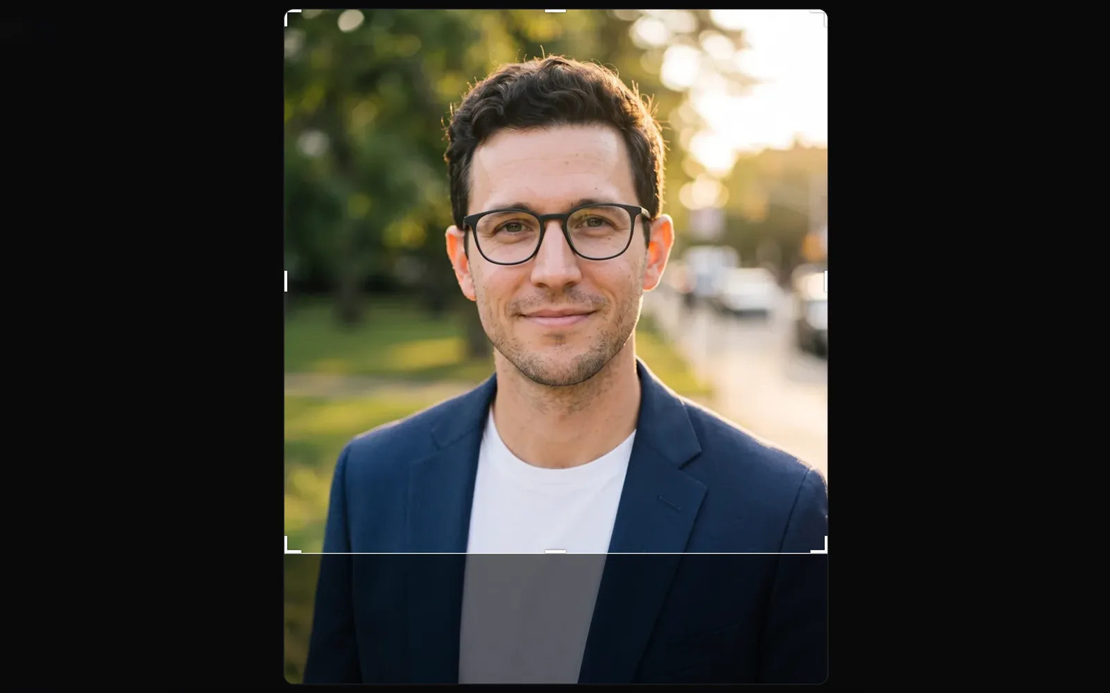 The crop box at 1:1 on the portrait, moved up to frame the face, with handles at its corners and edges and the part left out dimmed below it